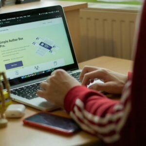 person using macbook pro on brown wooden table